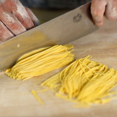 Frische gelbe Pasta auf Holzbrett geschnitten - Detailansicht